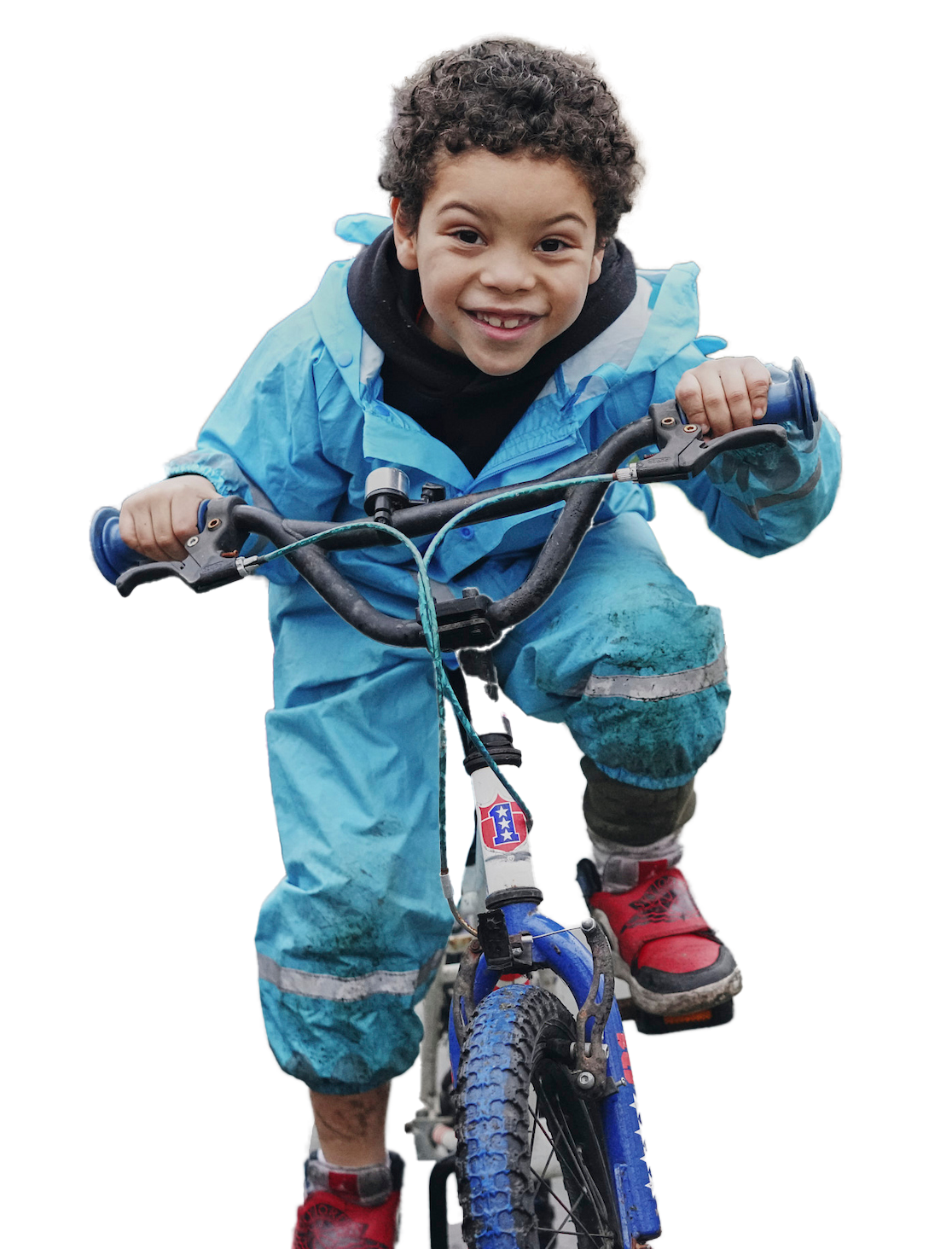 Smiling child in a blue jacket riding a small bike